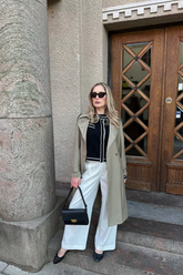 a lady wears a black crop cardigan with a classic trenchcoat